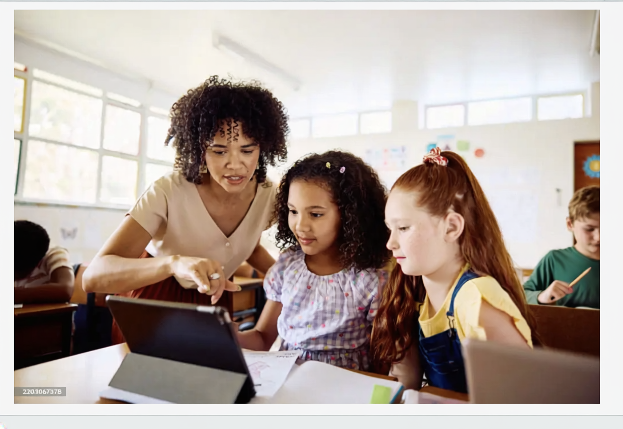Teacher helping students with tablet technology in classroom