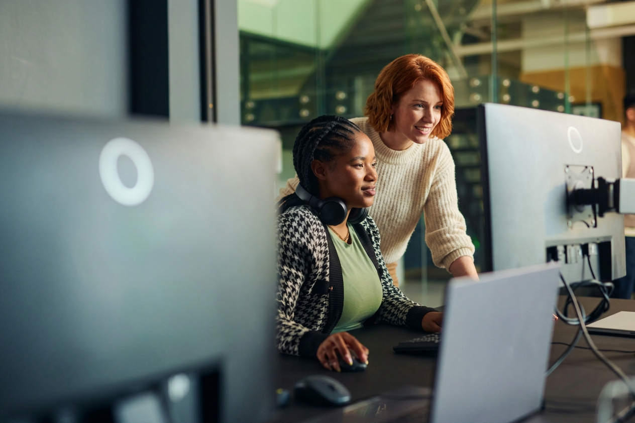 Two colleagues collaborating on AI feature strategy at a computer